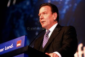 Mann in Anzug hält Rede am Rednerpult mit SPD-Logo vor dunkelblauer Kulisse.